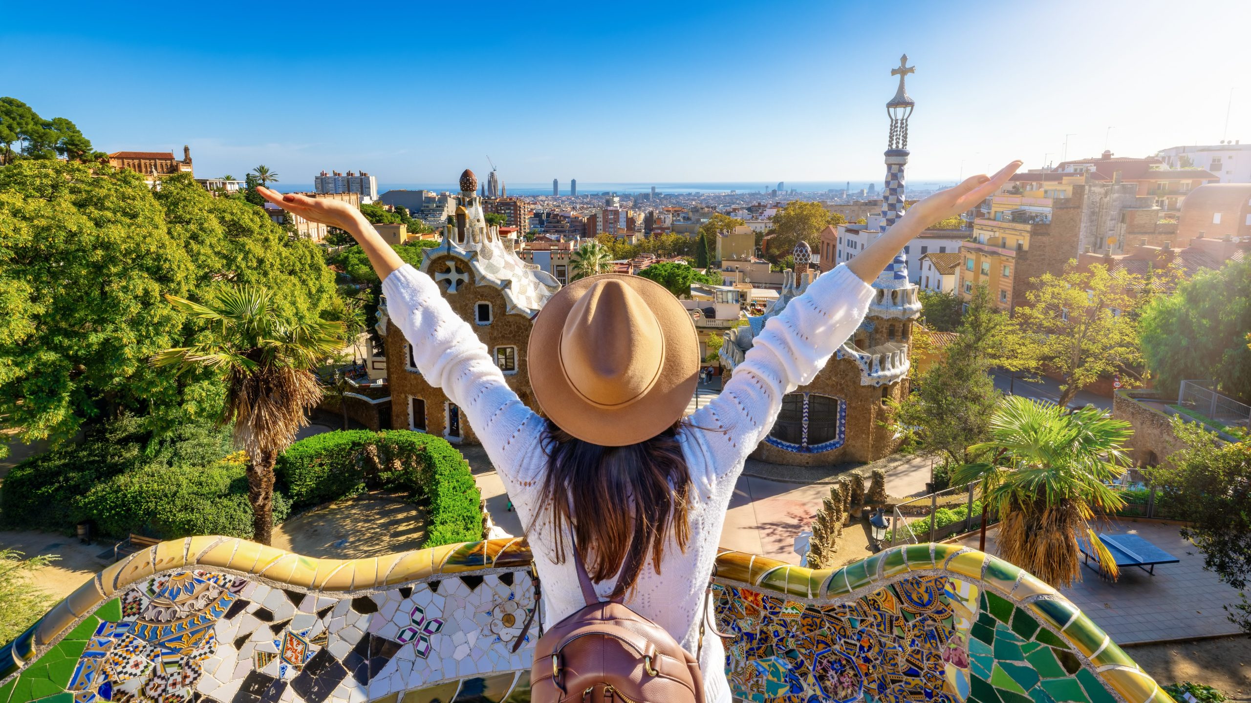 Viajera con los brazos abiertos frente al panorama de Barcelona desde el Parque Güell